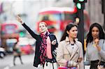 Woman signaling for taxi on city street