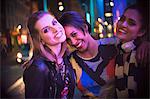 Women smiling together outside of store at night