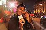 Couple taking picture together with cell phone at night