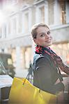 Woman with shopping bag crossing city street