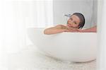 Smiling woman taking bath in modern bathroom