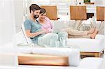 Couple using laptop together on daybed in modern living room