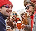 Friends celebrating with drinks in snow