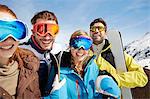 Friends carrying skis on mountain top