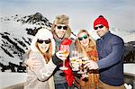 Couples celebrating with drinks in the snow