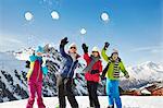 Family throwing snowballs on mountain top