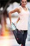 Woman stretching legs on city street