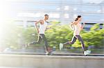 Couple running through city streets together