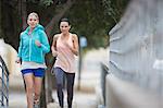 Women running through city streets together