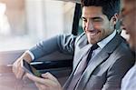 Businessmen looking at cell phone in car