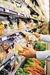 Close up of man comparing produce in grocery store