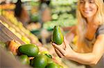 Close up of woman holding produce in grocery store