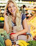 Woman talking on cell phone while shopping in grocery store