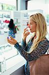 Woman smelling perfume in drugstore