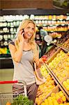 Woman talking on cell phone and shopping in grocery store