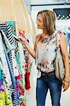 Woman checking price tags while shopping in clothing store