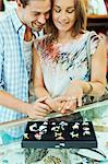 Couple admiring jewelry together in store