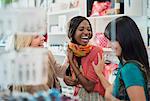 Women laughing together in clothing store