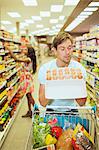 Man examining carton of eggs in grocery store