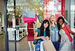 Women carrying shopping bags outside clothing store