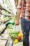 Man carrying full shopping basket in grocery store