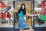 Woman carrying shopping bags outside clothing store