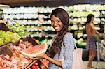 Woman shopping in produce section of grocery store