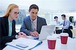 Business people working on laptops at table