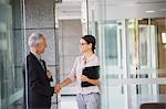 Business people shaking hands in office building