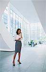 Businesswoman talking on cell phone in office building