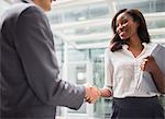 Business people shaking hands outside of office building