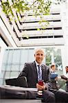 Businessman working on bench outside of office building