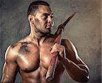 Muscular man holding pickaxe