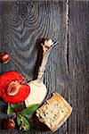 Blue cheese and fruits on a wooden background.