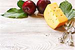 Delicious cheese and plum on a wooden board. Food ingredients background. Selective focus.
