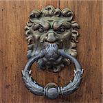 Italy. Ancient knocker on old wood door.