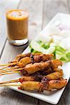 Tasty chicken satay on wooden dining table, one of famous Malaysian local dishes.