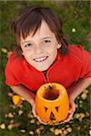 Boy with a Halloween pumpkin jack-o-lantern looking up