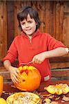 Boy carving his jack-o-lantern for Halloween - removing the seeds