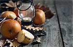 Ripe asian pears, lantern with candle and fall leaves on wooden table. Autumn concept. Selective focus. Copyspace background.