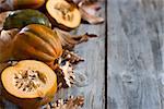 Decorative small pumpkins on fall leaves and wooden background. Selective focus. Copyspace background.