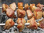 Shashlik (shish kebab) prepared on the metal skewers outdoors