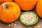 a bowl of fresh pumpkin seeds on weathered wood