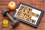diet, sleep, exercise and mindset - vitality concept - abstract in vintage letterpress wood type on a digital tablet with a dumbbell, apple and tape measure