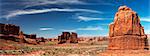 Red car driving past sandstone rock formations, Arches National Park, Utah, USA