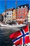 Boats on waterfront with Norwegian flag, Nyhavn Harbour, Copenhagen, Denmark