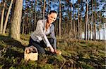 Portrait of Young Woman Collecting Mushrooms in Scots Pine (Pinus sylvestris) Forest in Early Autumn, Bavaria, Germany