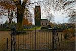 Gate and cemetery in small village in Friesland with Friesland style church in autumn, Netherlands