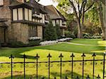 View of iron fence and house exterior in summer, Toronto, Ontario, Canada