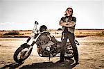 Portrait of mature male motorcyclist on arid plain, Cagliari, Sardinia, Italy